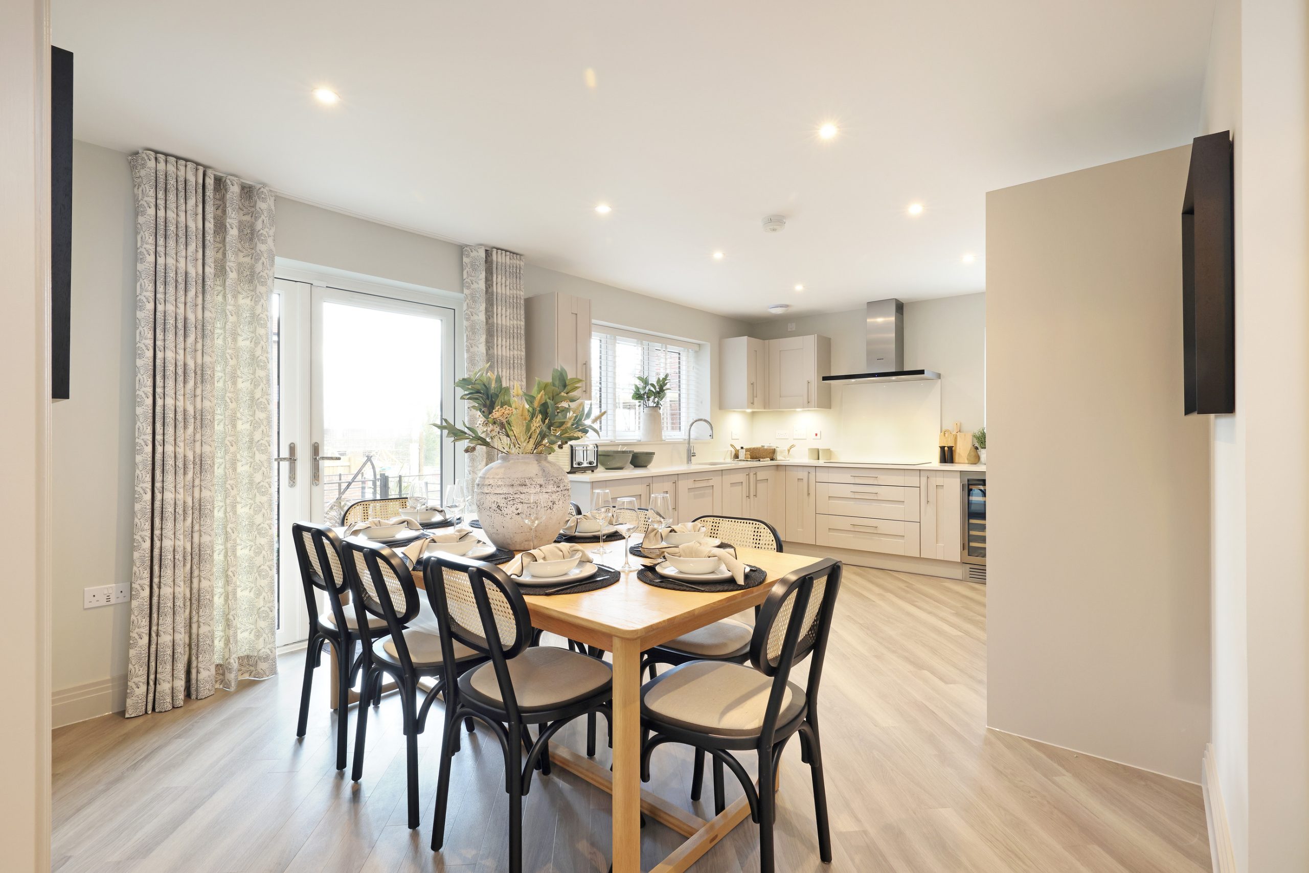 Modern kitchen with dining area, set table, and a door leading to the back of the house.