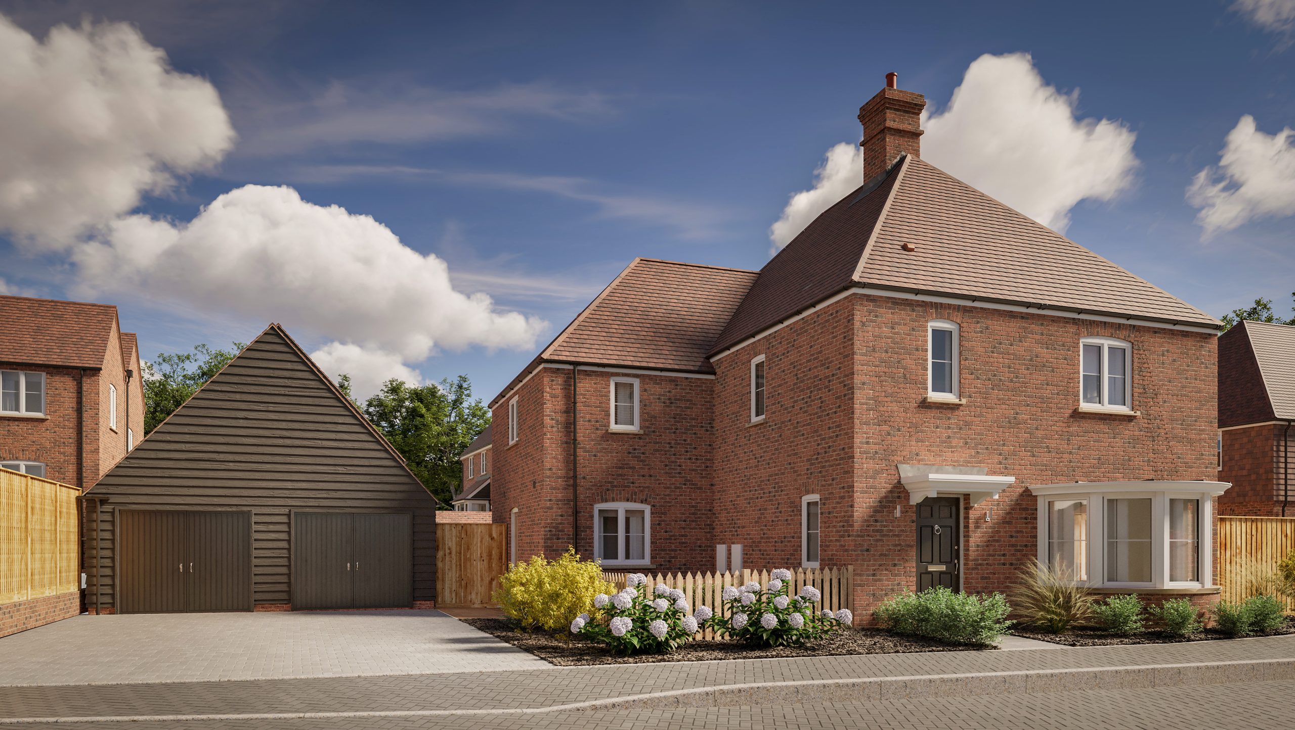 Large brick house with pitched roof, separate double garage on the drive, and a well kept front garden