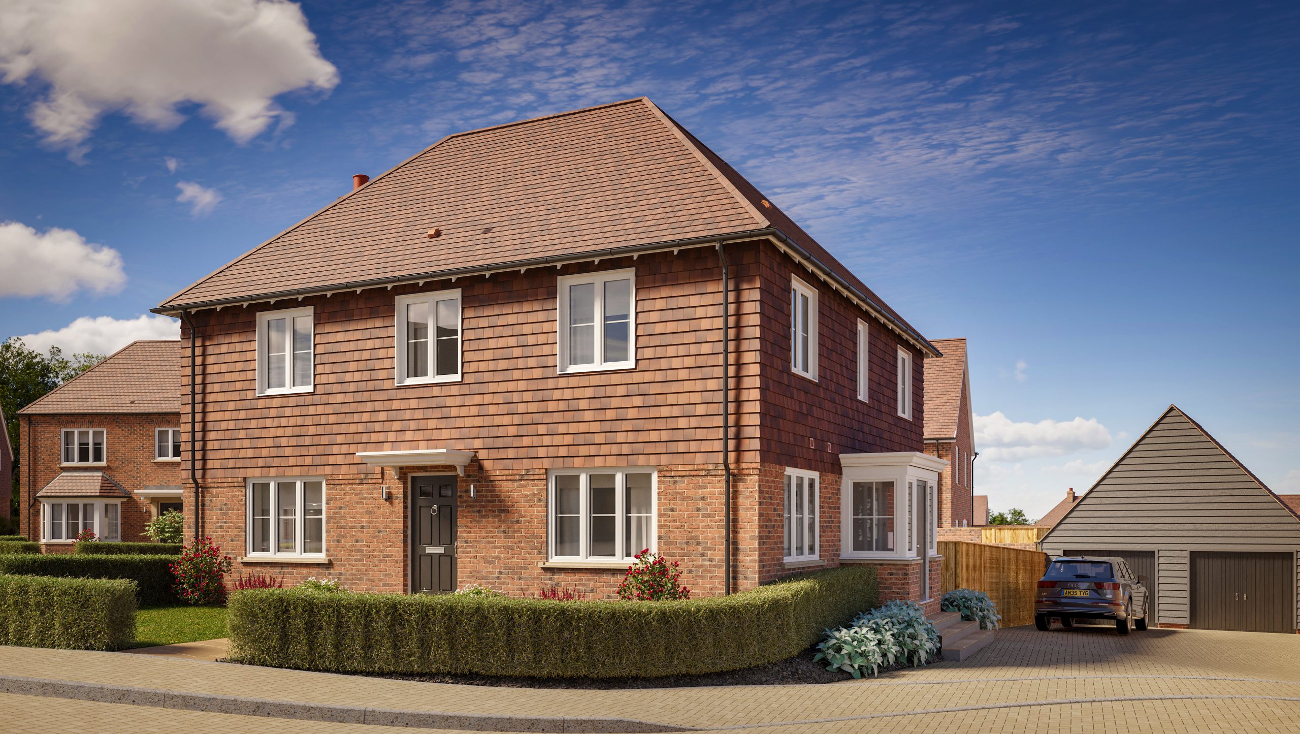 Two-story brick house with a tiled roof, large driveway, and a hedge around the outside of the front garden.